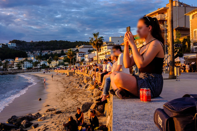 Fotografinnen sitzen auf der Kaimauer in Port de Sollér und Fotografieren den Sonnenuntergang